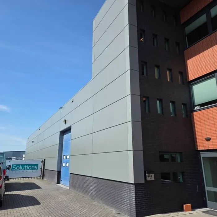 Zijgevel van de loods bij Wesselink Buunk na reiniging en schilderwerk van de gevelplaten