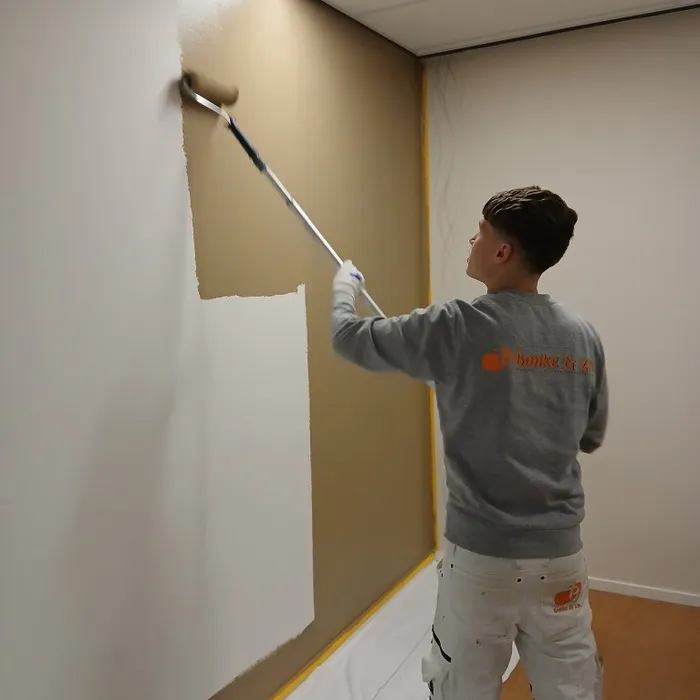 Voor en tijdens schilderwerk van de wand in de afscheidskamer op de SEH in Enschede met kleur RAL 1019.