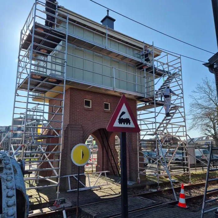 Schilders van Bonke & Zn. op de steiger aan het werk bij de watertoren van Museum Buurtspoorweg