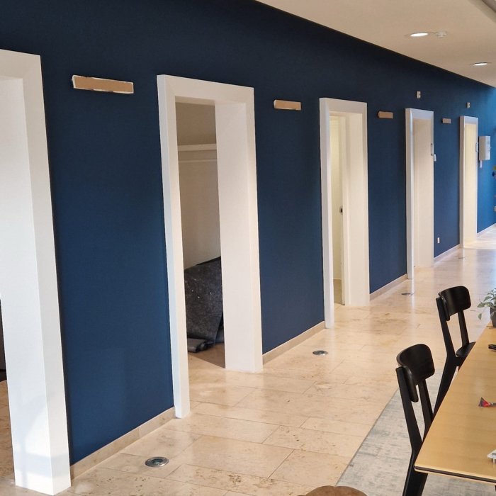 Binnenschilderwerk met blauwe accentwand en strak geschilderde kozijnen in kantoor OF-US Enschede
