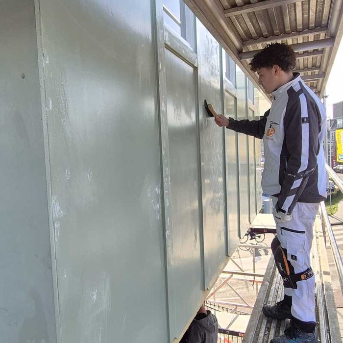 Schilder van Bonke & Zn. brengt verflaag aan op de gevelbeplanking van de watertoren, Museum Buurtspoorweg Haaksbergen