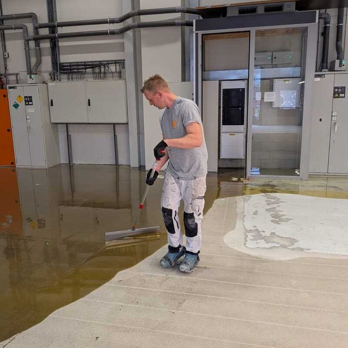 Medewerker van Bonke & Zn. brengt epoxy vloercoating aan in technische ruimte bij Grolsch