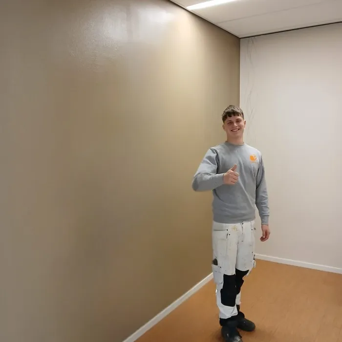 Twee leerlingen van Schildersbedrijf Bonke & Zn. na het schilderwerk van de afscheidskamer op de SEH in Enschede met wand in RAL 1019.